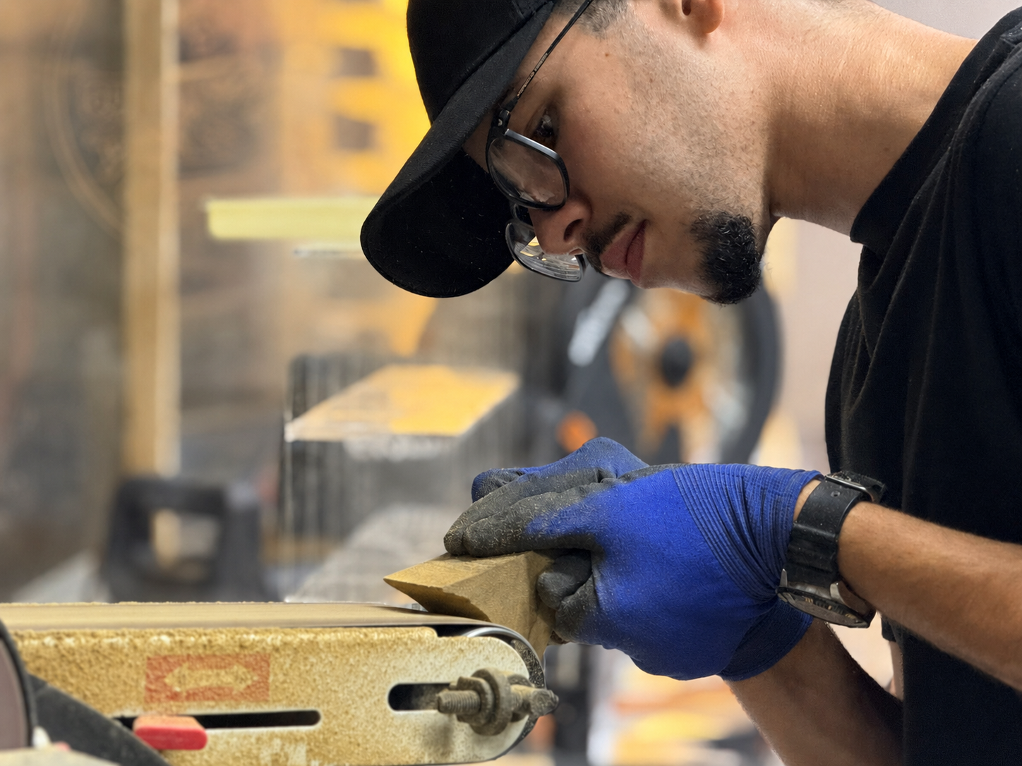 Jad Aoujil hand-sanding a timber edge in his workshop